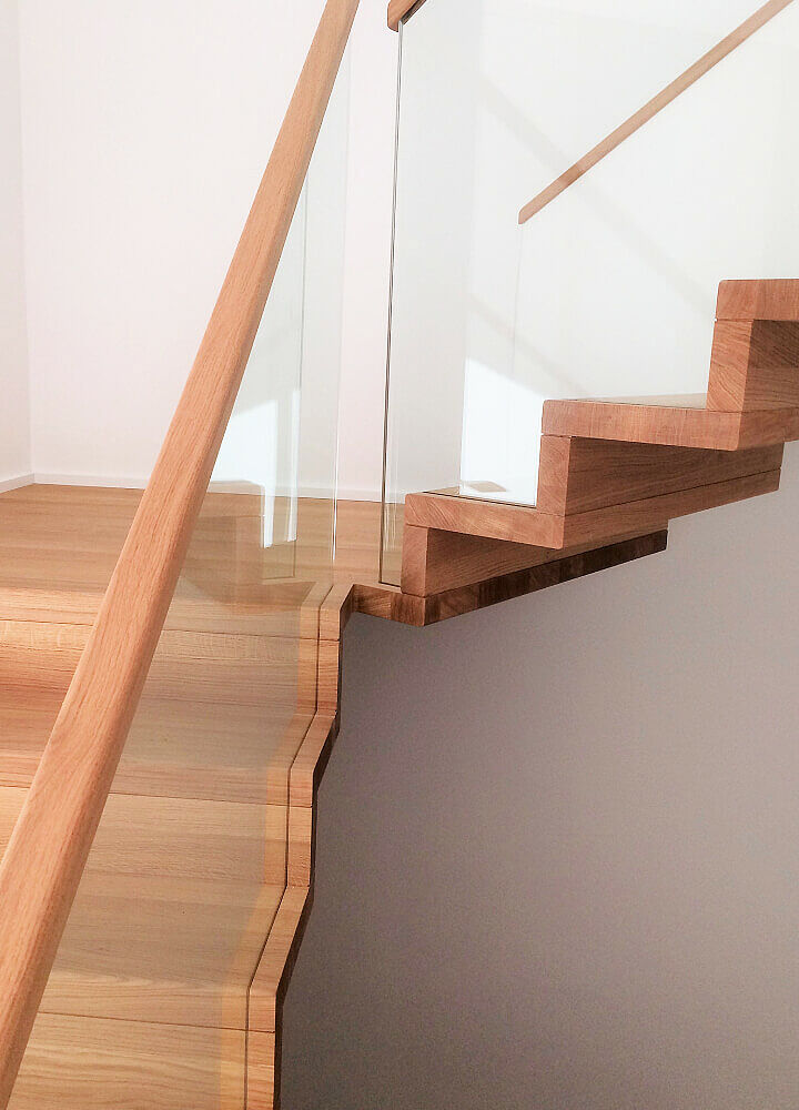 Faltwerktreppe mit Klarglasgeländer und Handlauf aus Massivholz